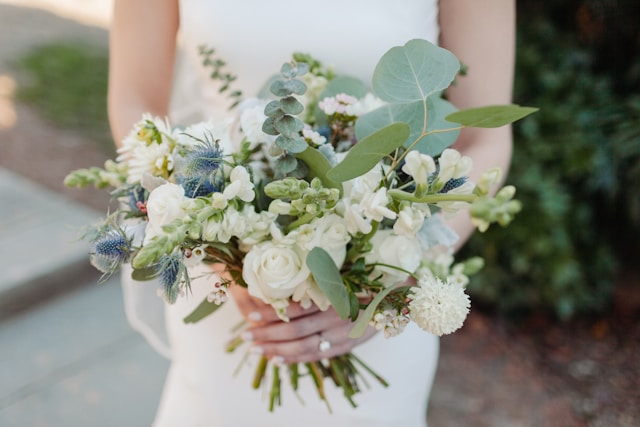 mlada u vjenčanici drži buket cvijeća